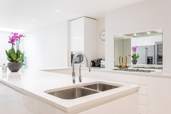 Contemporary kitchen island with sink and mirrored splashback