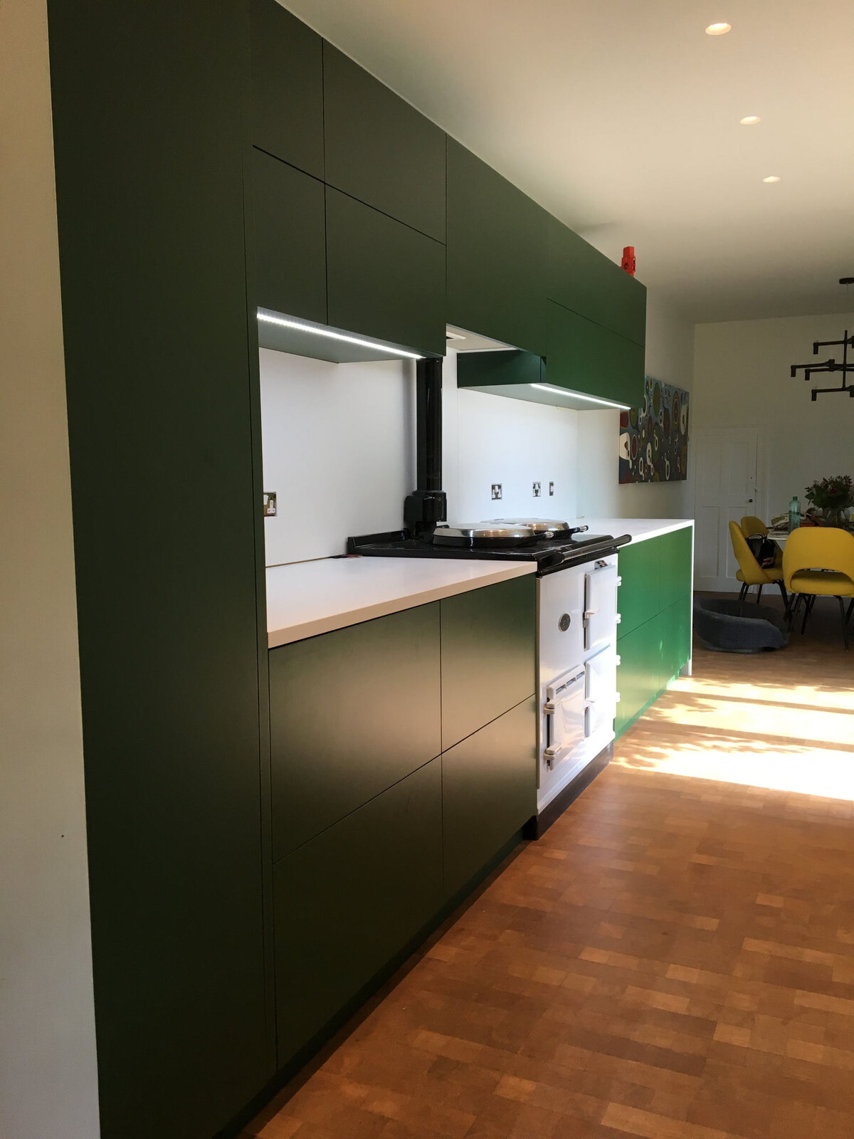 Forest green handleless kitchen with white AGA