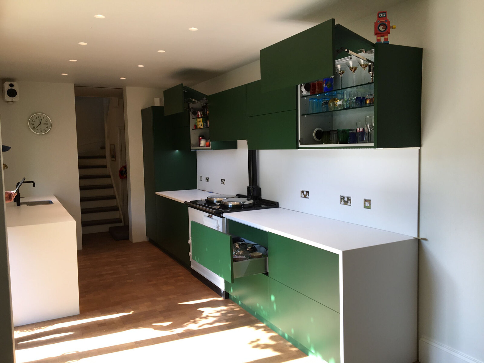 Forest green kitchen with open glass-front display cabinets