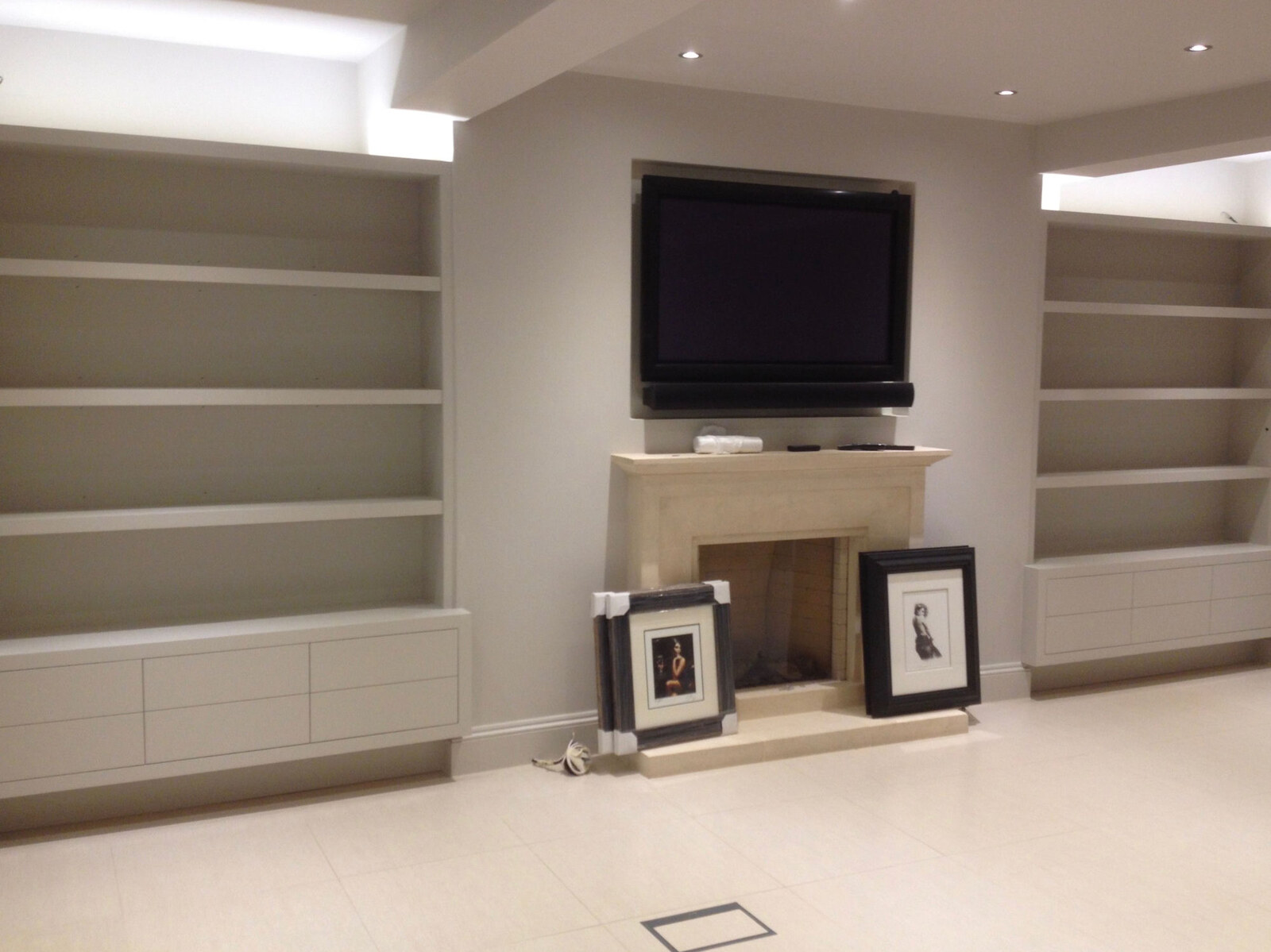 White alcove shelves and stone fireplace with TV