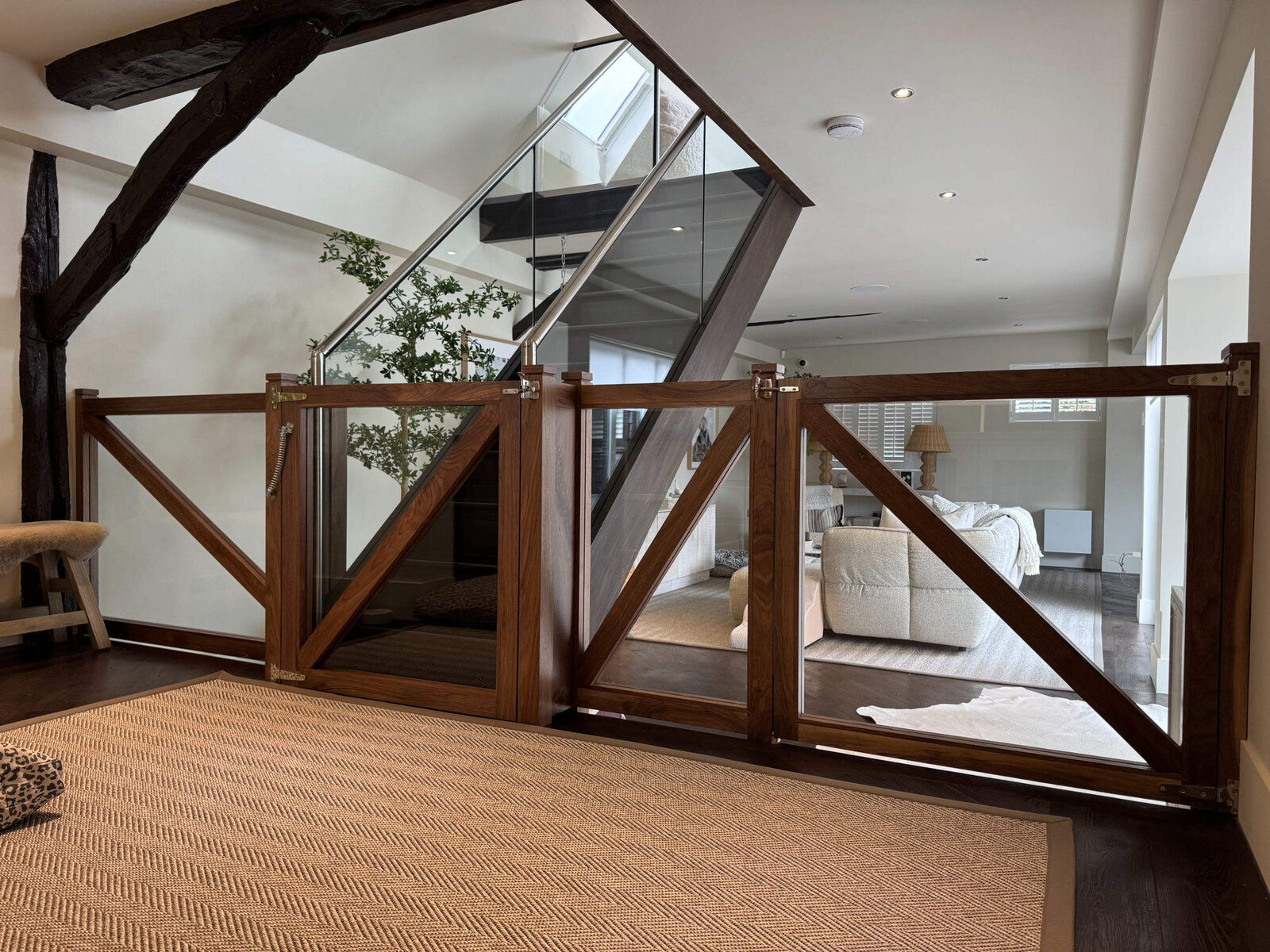 Walnut framed gates with diagonal glass insets and glass balustrade